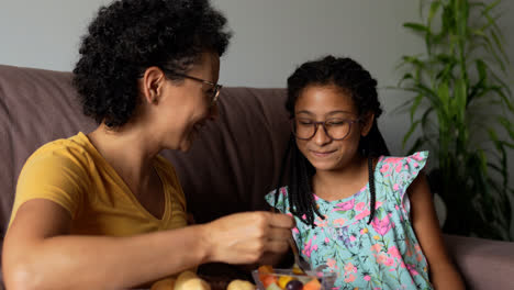 Woman-giving-fruit-to-her-daughter